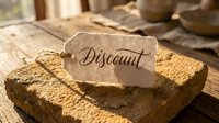 Discount label tag on rustic stone block with warm wooden background, soft natural light, retail sale and shopping promotion concept.