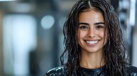 Young Hispanic woman with wet dark hair and bright smile against blurred background. Natural beauty portrait showing genuine happiness and confidence.