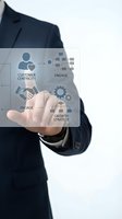 Businessman in dark suit holding transparent digital interface displaying customer centricity, engagement, and growth strategy icons for business development and marketing.