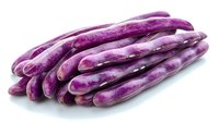Fresh purple string beans isolated on white background, showing natural marbled pattern and glossy surface. Organic produce for healthy cooking and food design.