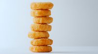 Stacked golden crispy onion rings arranged vertically on white background, isolated food photography for menu and restaurant advertising purposes.
