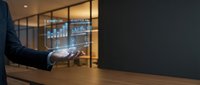 Businessman presenting holographic financial data charts and graphs in modern office environment for business analytics and digital technology presentations.