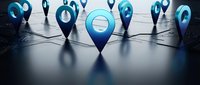 Blue location pins connected by network lines on dark surface representing GPS navigation and digital mapping technology for business applications.