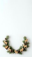 Festive evergreen garland with wooden reindeer ornaments and berries arranged in crescent shape on white background, ready for holiday decorating and seasonal design projects.