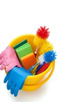 Colorful cleaning supplies in yellow bucket with rubber gloves, sponges and brushes isolated on white background for household chores and maintenance tasks.