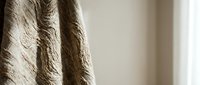 Elegant beige textured curtains with intricate woven pattern hanging in modern interior space creating warm atmospheric lighting for home decor and window treatment.