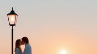 Romantic couple silhouette kissing under vintage street lamp at golden sunset creating intimate atmosphere for wedding and love concepts.