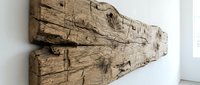 Rustic weathered wooden beam with rough texture and natural cracks, mounted on a white wall, showcasing aged wood grain for interior design.