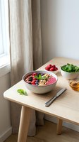 Healthy smoothie bowl with fresh berries, granola and mint on wooden table. Nutritious breakfast setup with natural ingredients for wellness lifestyle.