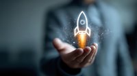 Glowing rocket hologram floating above businessman's palm with sparkle effects, representing business growth, startup launch and innovation concept.