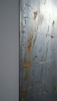 Weathered metal surface with rust stains and scratches showing industrial decay and corrosion patterns for grunge design projects.