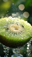 Fresh kiwi fruit splashing in crystal clear water with sparkling droplets and bokeh effects against green background, macro photography capturing dynamic motion.