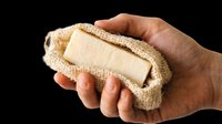 Soap bar wrapped in natural burlap cloth held in hand, isolated on transparent background. Ready for packaging design, product mockups, e-commerce, print-on-demand, and eco-friendly branding projects.