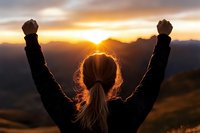 Woman celebrating success with raised arms at mountain summit during golden sunrise, achievement and triumph concept in nature landscape.