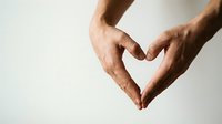 Hands forming a heart shape against a light background, symbolizing love, care, and unity for health or charity campaigns.