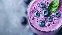 Fresh blueberry smoothie with mint garnish in glass, healthy breakfast drink with antioxidants, purple berry beverage for wellness and nutrition lifestyle.