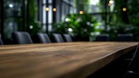 Empty wooden table with blurred restaurant interior background, selective focus on natural wood surface texture with warm ambient lighting and green plants.
