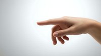 Human hand reaching out with extended finger in gentle touching gesture against clean white background for design projects.