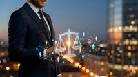 Professional businessman in dark suit holding glowing digital scales of justice with network connections against blurred city skyline at dusk.