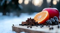 Fresh winter composition with orange slice, red apple, star anise, cinnamon sticks, blackberries and spices on rustic wooden board against snowy bokeh background.