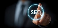 Professional businessman pointing at glowing SEO circle icon on dark background, demonstrating search engine optimization concept for digital marketing.