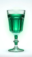 Goblet filled with sparkling green beverage and ice cubes on white background, isolated for beverage, cocktail, and refreshment design projects.