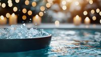 Crushed ice in black bowl with golden bokeh lights background creates luxurious atmosphere for cocktail party or beverage presentation setting.
