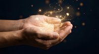 Cupped hands holding glowing golden light particles and sparkles against dark background, symbolizing hope, magic, energy, and spiritual power for wellness concepts.