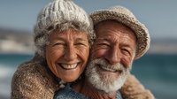 Happy senior couple embracing on beach vacation, elderly man and woman smiling together by ocean, retirement lifestyle and love in golden years.