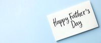 Happy Father's Day handwritten message on white card against light blue background with copy space for greeting cards and social media banners.