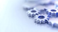 Metallic gear wheels on light background with selective focus and copy space, representing business teamwork and mechanical processes.