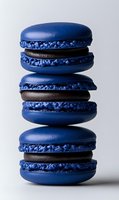 Stack of three blue macarons with chocolate filling on white background, French pastry dessert for bakery menu design.