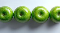 Fresh green apples in row on white background, showing vibrant color and natural texture. Clean minimal composition for healthy eating and nutrition concepts.