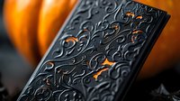 Ornate black playing card deck with embossed floral pattern illuminated by warm orange glow against dark background, luxury gaming accessory for magic and poker.