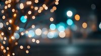 Dreamy bokeh lights creating magical atmosphere with golden and turquoise glowing circles on dark background, defocused night illumination effect.