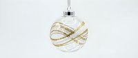 Elegant white Christmas ornament with gold glitter stripes hanging on silver hook against clean white background for holiday decorating and festive designs.
