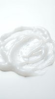 Creamy white cosmetic product with smooth, swirled texture isolated on white background, suitable for skincare, beauty, and cosmetics design applications.