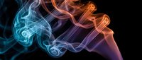 Colorful smoke swirls in blue, orange, and purple tones against a dark black background, creating an abstract, ethereal art effect.