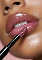 Close-up of glossy pink lips being lined with precision using dark lip pencil, showcasing professional makeup application technique on dark skin tone model.