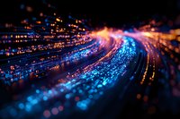 Abstract light trails with blue and orange glowing particles creating dynamic motion effect against dark background, suggesting high-speed data transfer or fiber optics.