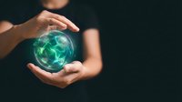 Hands protecting glowing green earth globe with network connections symbolizing environmental protection and global sustainability responsibility.
