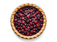 Homemade berry pie with golden crust filled with fresh raspberries and blackberries, isolated on white background for baking and food design projects.