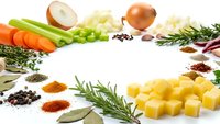 Fresh vegetables, herbs and spices arranged in circle frame on white background. Cooking ingredients including carrots, onions, potatoes, rosemary for culinary recipes.