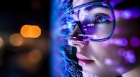 Young Asian woman in glasses looking at programming code projected on her face in purple neon light, side view close up with bokeh background.