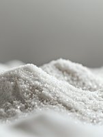 White granulated sugar in soft dunes formation on light background, macro photography showing crystalline texture and gentle shadows for culinary and food industry use.