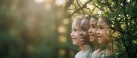 Diverse group of young children standing in profile outdoors with warm sunlight filtering through green foliage creating natural bokeh background.