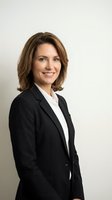 Professional middle-aged Caucasian businesswoman in black suit smiling confidently against neutral background for corporate headshot and business marketing.