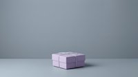 Stacked purple and lavender gift boxes with ribbon on neutral background, suitable for holiday, celebration, and retail design projects.