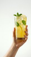 Hand holding refreshing lemon mint cocktail with ice cubes in tall glass against neutral background for beverage and summer drink concepts.