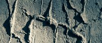 Cracked dry earth surface with deep fissures and textured mud patterns showing drought conditions and arid landscape for environmental concepts.